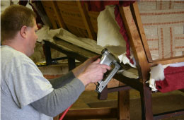 man replacing fabric on a vintage couch