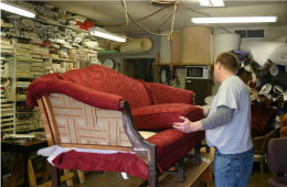 man replacing fabric on a vintage couch