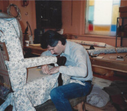 man replacing fabric on an old chair