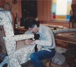 man replacing fabric on an old chair