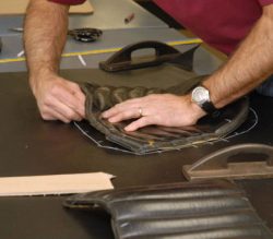 man repairing custom leather cushion